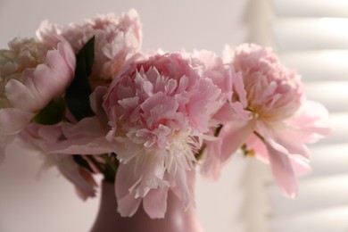 Photo of Bouquet of beautiful peonies in vase indoors, closeup