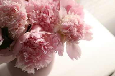 Photo of Bouquet of beautiful peonies in vase indoors, closeup