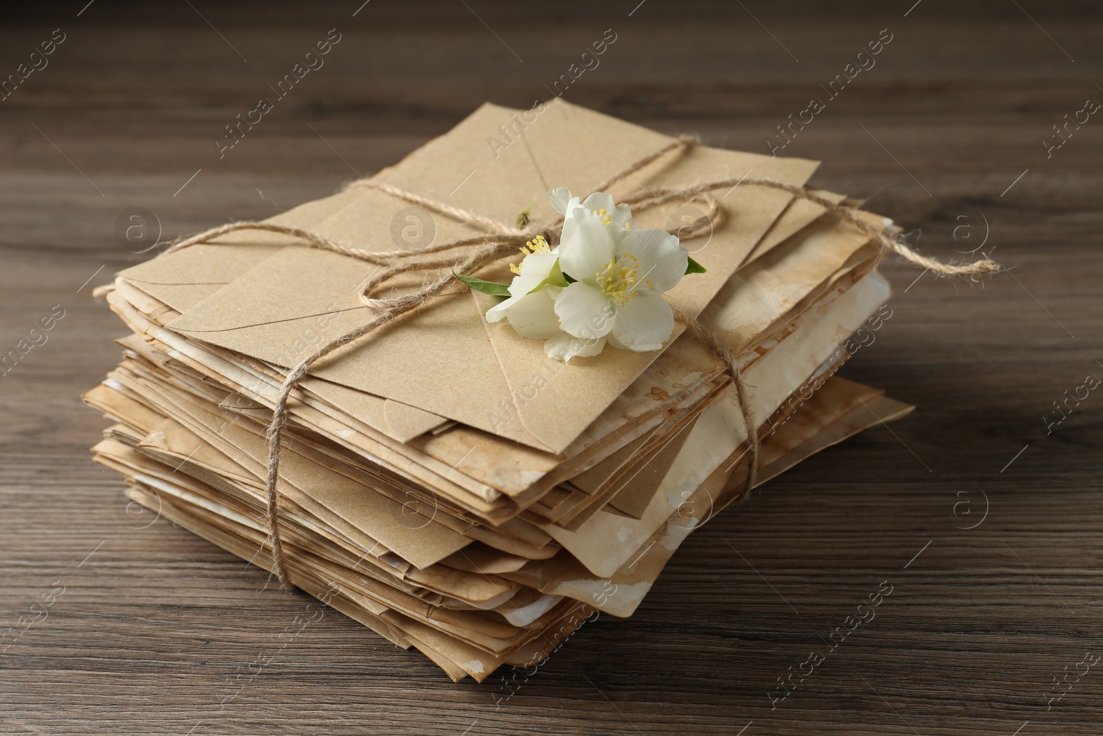 Stack of love letters and flowers on wooden table, closeup Photo of Stack of love letters and flowers on wooden table, closeup