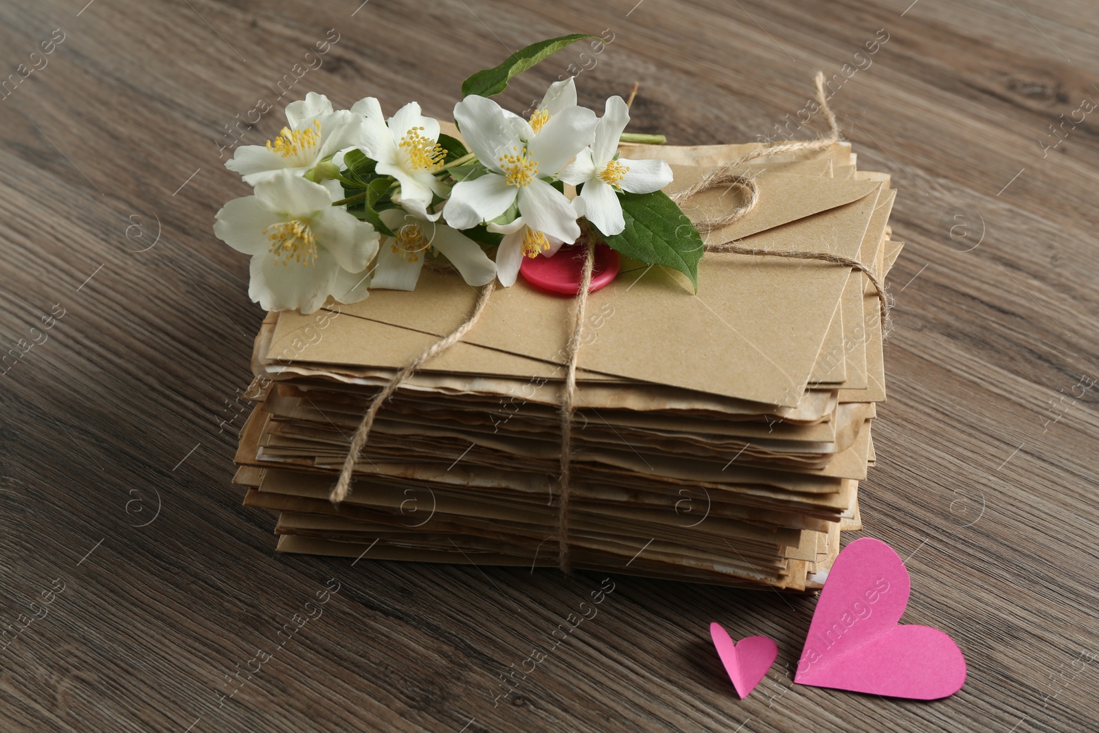 Stack of love letters, paper hearts and flowers on wooden table, closeup Photo of Stack of love letters, paper hearts and flowers on wooden table, closeup