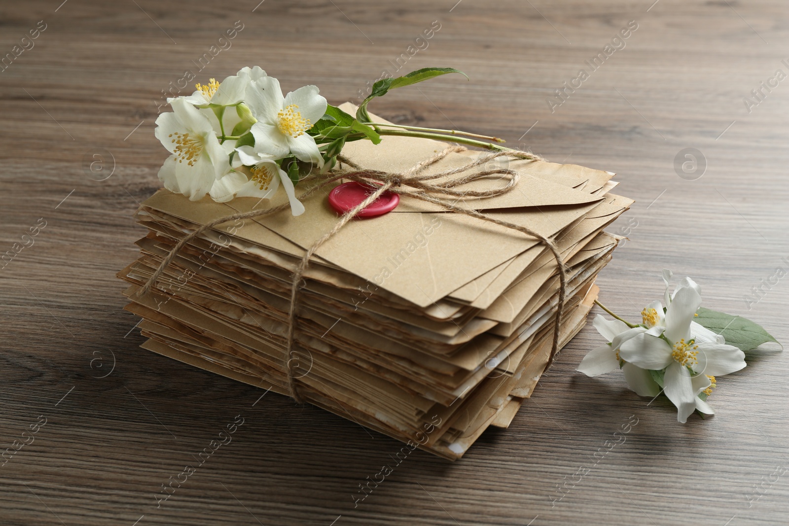Stack of love letters and flowers on wooden table, closeup Photo of Stack of love letters and flowers on wooden table, closeup