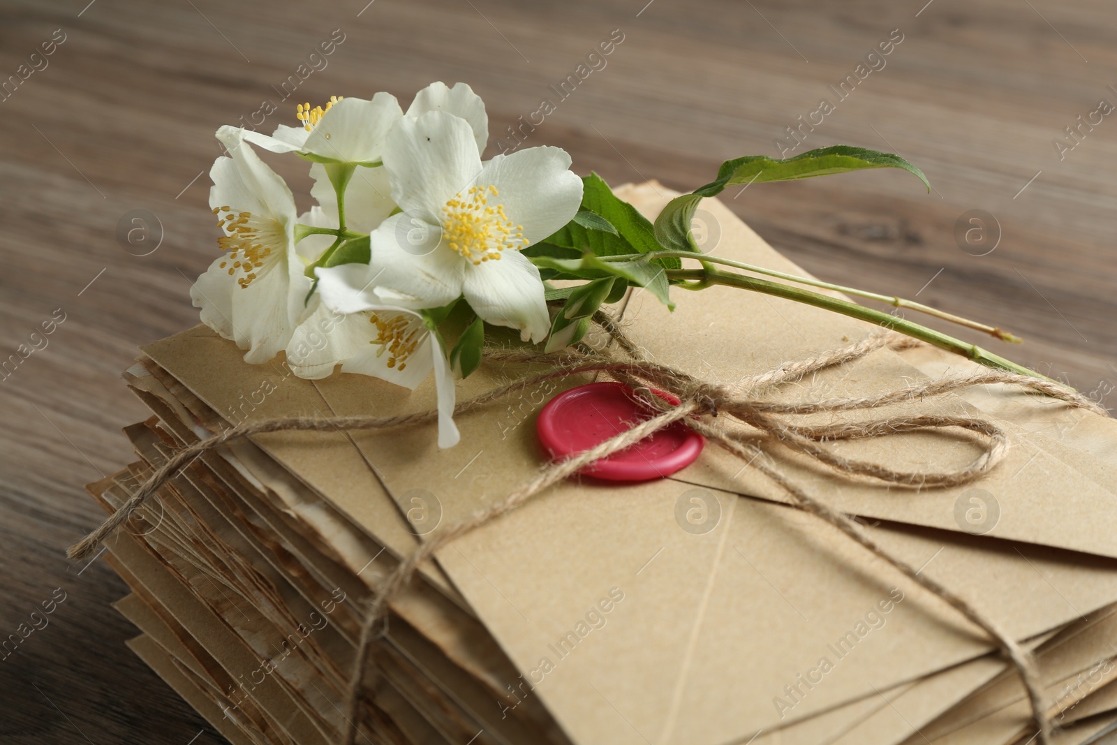 Stack of love letters and flowers on wooden table, closeup Photo of Stack of love letters and flowers on wooden table, closeup