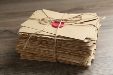 Photo of Stack of love letters on wooden table, closeup