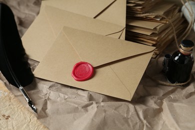 Photo of Stack of love letters, quill and ink on table, closeup