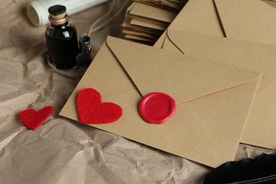 Photo of Stack of love letters, paper hearts and ink on table, closeup