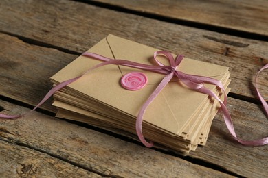 Photo of Stack of love letters on wooden table, closeup