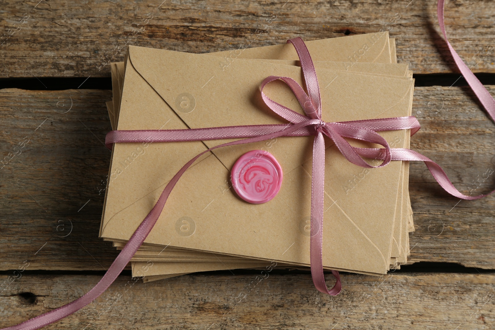 Stack of love letters on wooden table, top view Photo of Stack of love letters on wooden table, top view