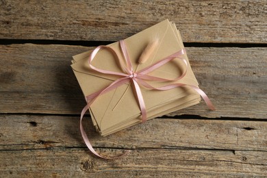 Photo of Stack of love letters on wooden table, top view