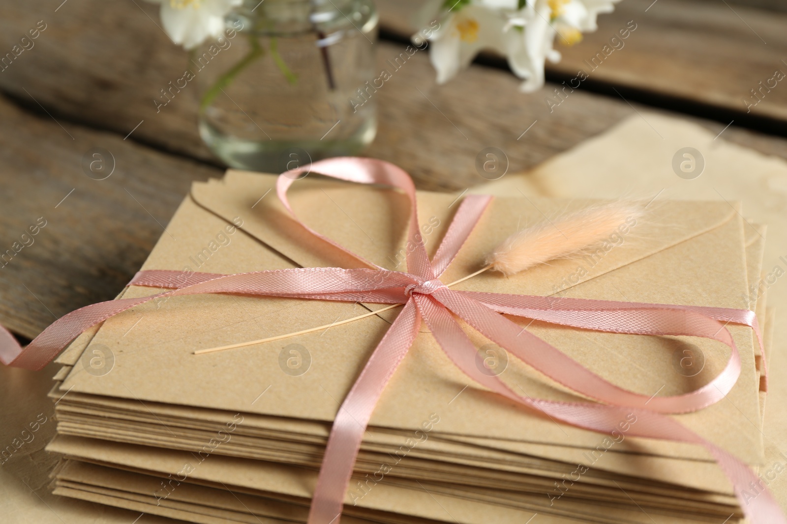 Stack of love letters and parchment sheet on wooden table, closeup Photo of Stack of love letters and parchment sheet on wooden table, closeup