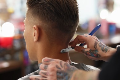 Photo of Professional barber working with client in barbershop, closeup