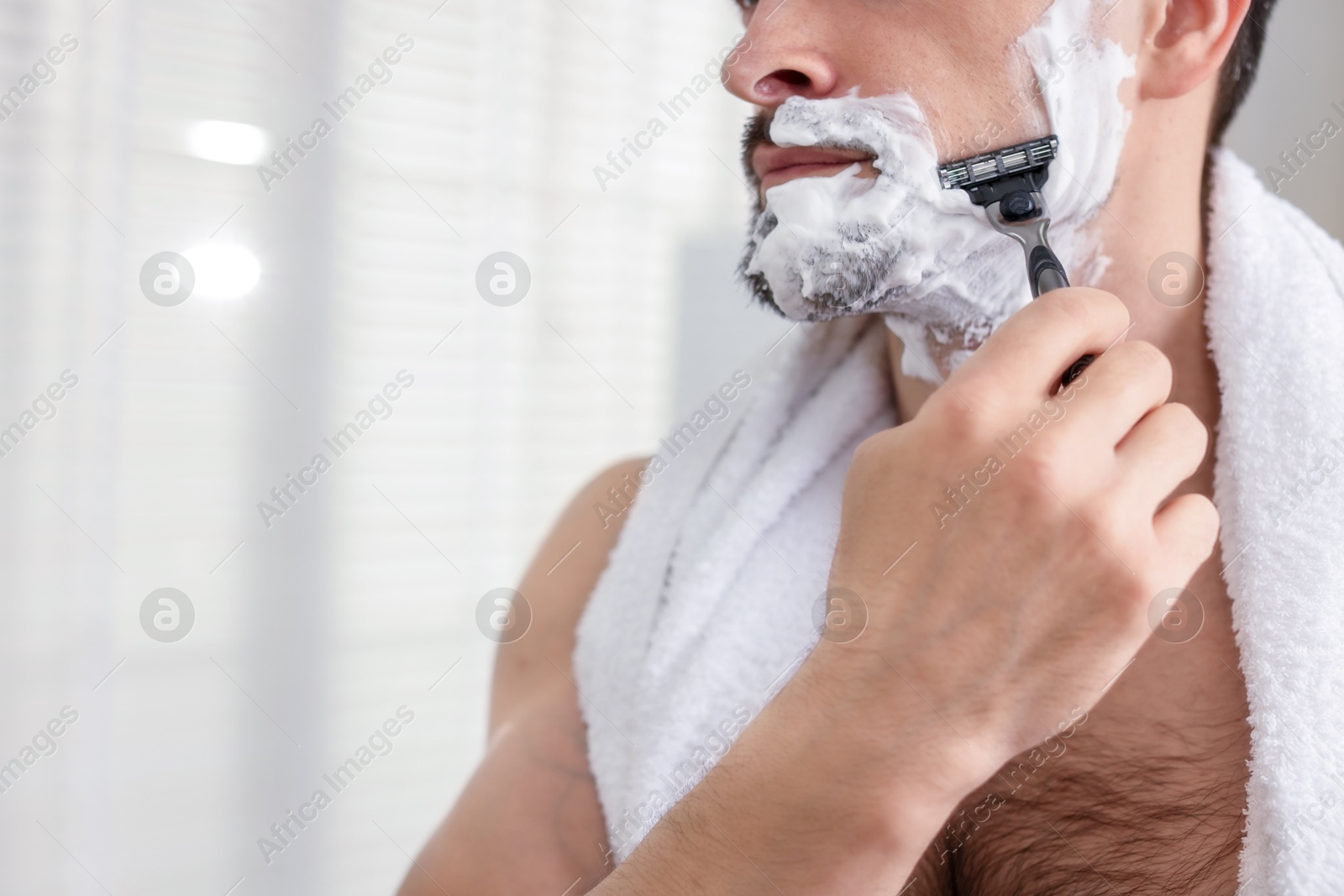 Man shaving with razor at home, closeup. Space for text Photo of Man shaving with razor at home, closeup. Space for text