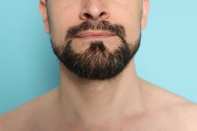 Photo of Man before shaving on light blue background, closeup