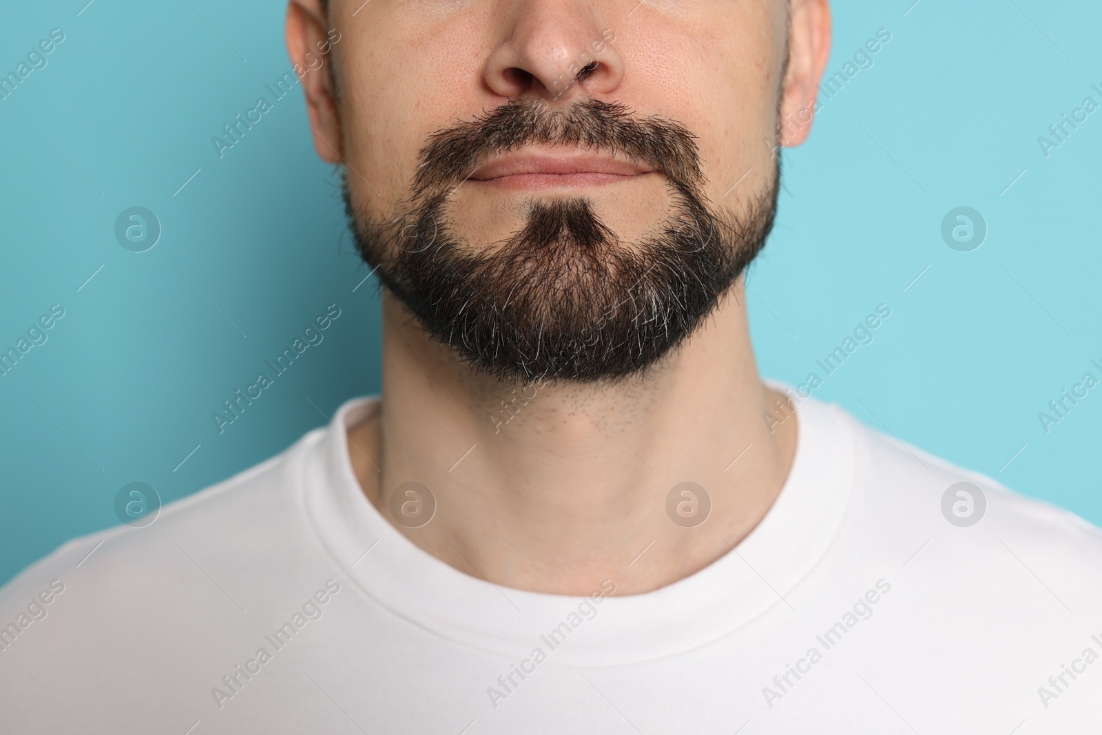 Man before shaving on light blue background, closeup Photo of Man before shaving on light blue background, closeup