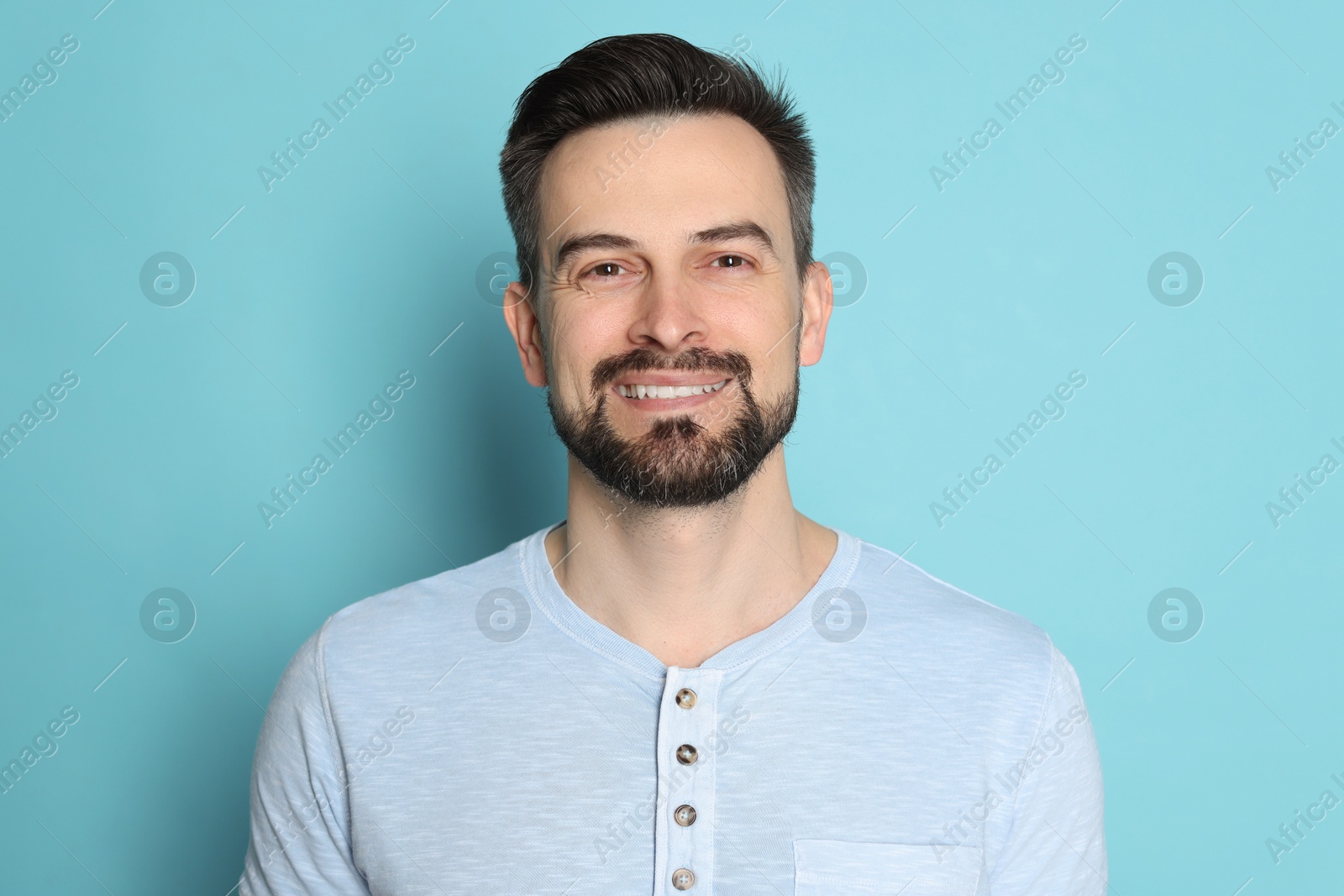 Smiling man before shaving on light blue background Photo of Smiling man before shaving on light blue background