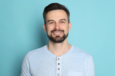 Photo of Smiling man before shaving on light blue background