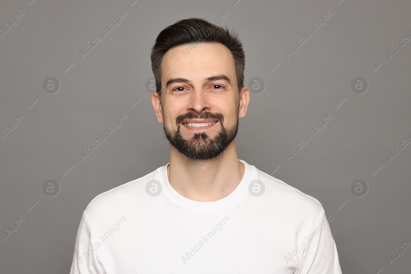 Smiling man before shaving on grey background Photo of Smiling man before shaving on grey background