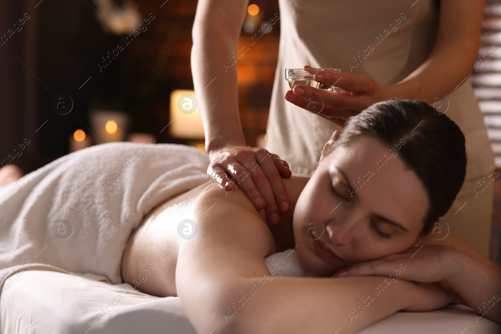 Woman receiving back massage with oil in spa salon Photo of Woman receiving back massage with oil in spa salon