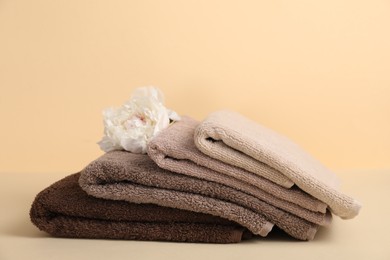 Photo of Soft towels and peony flower on beige background