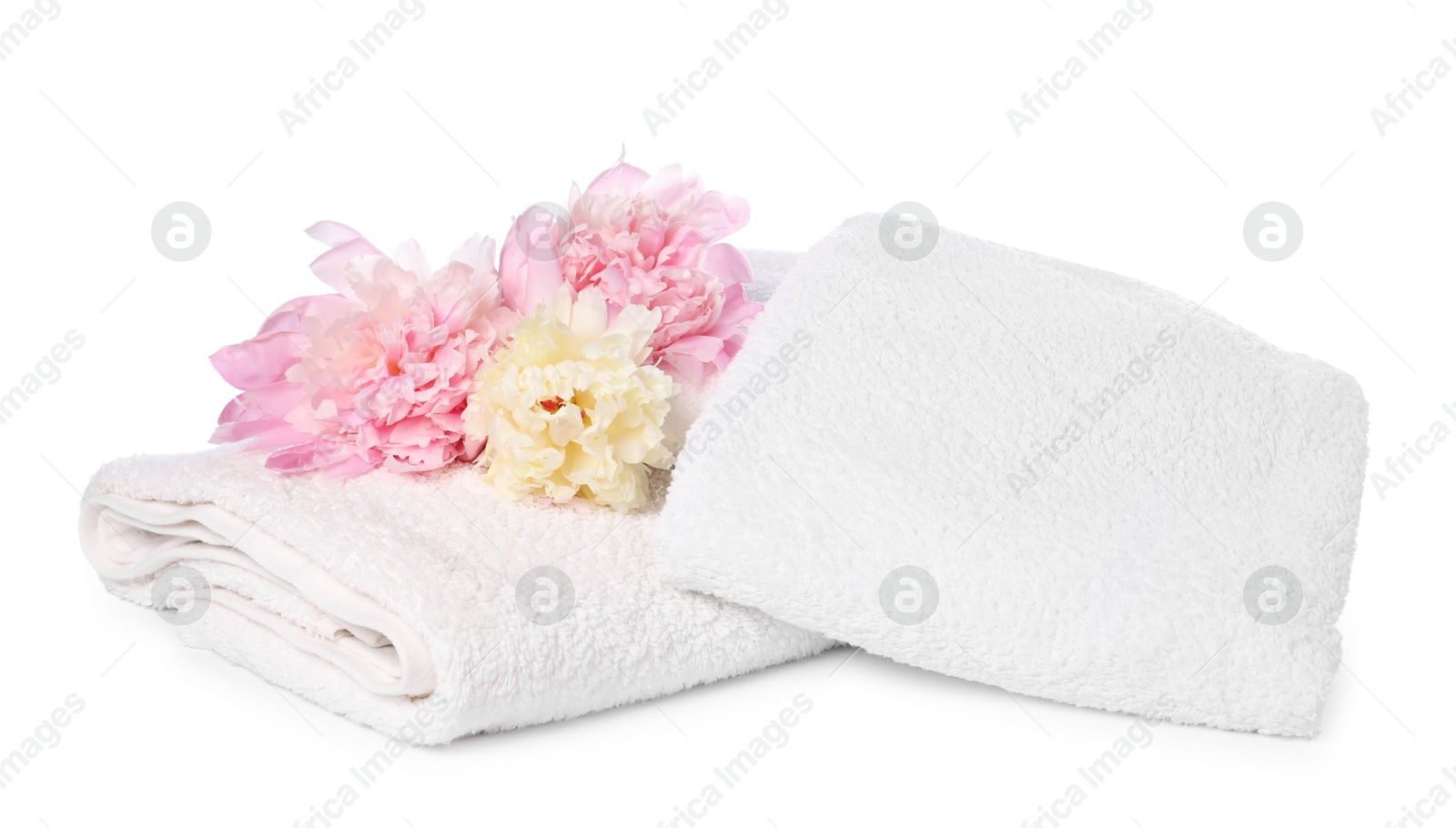 Soft towels and peony flowers isolated on white Photo of Soft towels and peony flowers isolated on white