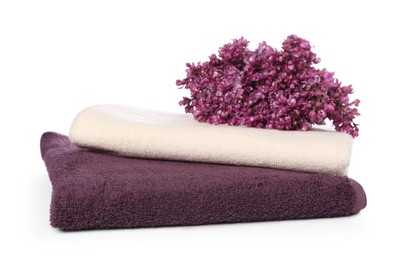 Photo of Soft towels and lilac flowers isolated on white
