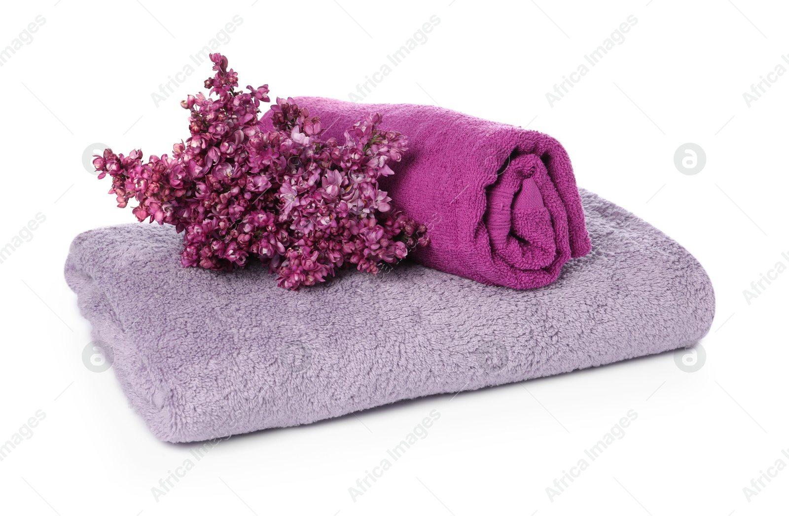 Soft towels and lilac flowers isolated on white Photo of Soft towels and lilac flowers isolated on white