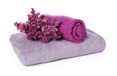 Photo of Soft towels and lilac flowers isolated on white