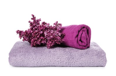 Photo of Soft towels and lilac flowers isolated on white