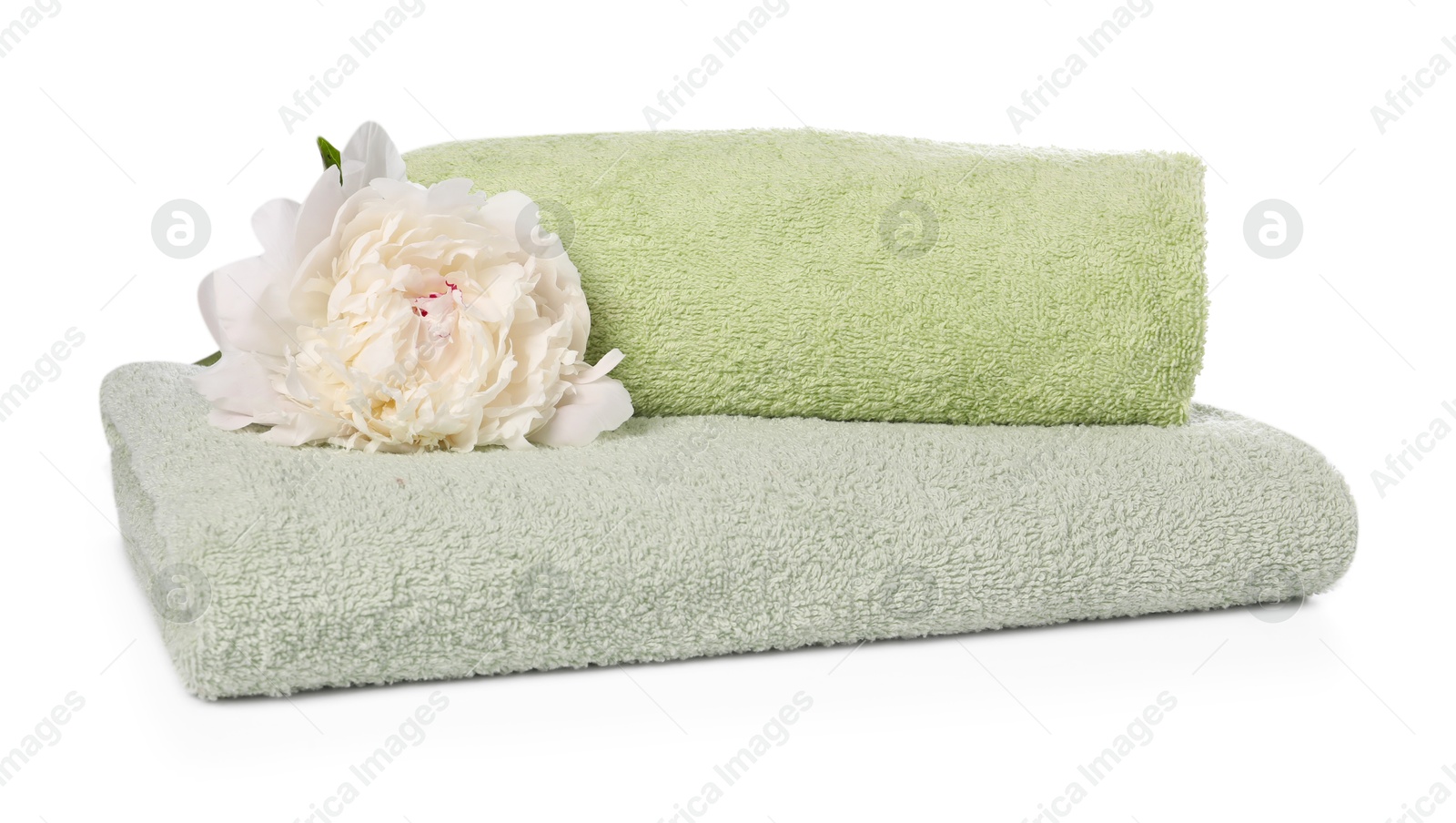 Soft towels and peony flower isolated on white Photo of Soft towels and peony flower isolated on white