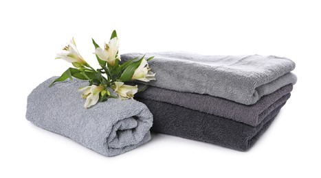 Photo of Soft towels and beautiful flowers isolated on white