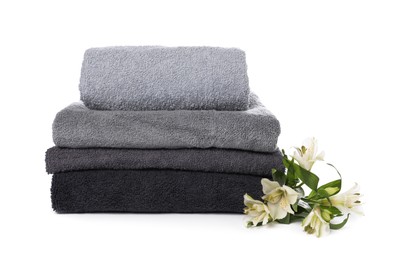 Photo of Stack of towels and beautiful flowers isolated on white