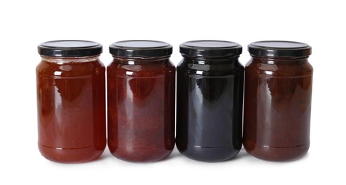 Photo of Different sweet jams in jars isolated on white