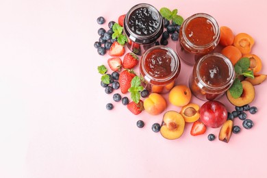Photo of Different jams in jars and ingredients on light pink background, flat lay. Space for text
