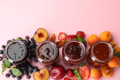 Photo of Different jams in jars and ingredients on light pink background, flat lay. Space for text