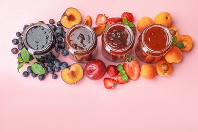 Photo of Different jams in jars and ingredients on light pink background, flat lay. Space for text
