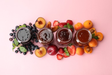 Photo of Different jams in jars and ingredients on light pink background, flat lay