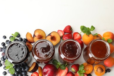 Photo of Different jams in jars and ingredients on white background, flat lay. Space for text