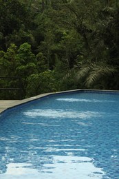 Photo of Outdoor swimming pool with clear water and green plants