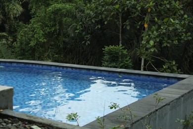 Photo of Outdoor swimming pool with clear water and green plants