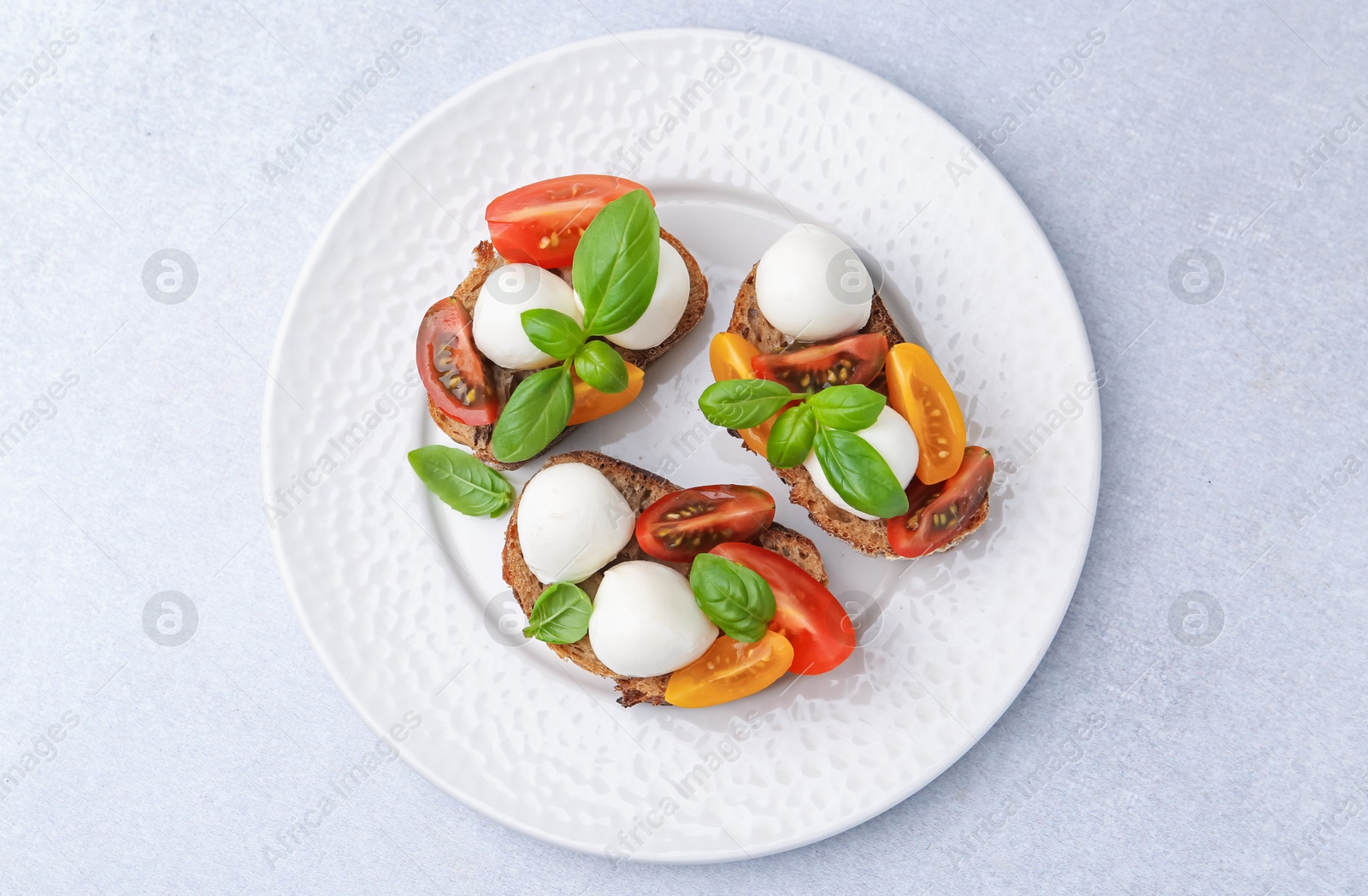 Tasty sandwiches with mozzarella cheese, tomatoes and basil on white table, top view Photo of Tasty sandwiches with mozzarella cheese, tomatoes and basil on white table, top view