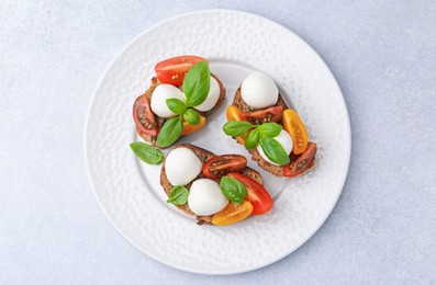 Photo of Tasty sandwiches with mozzarella cheese, tomatoes and basil on white table, top view