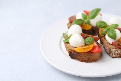 Photo of Tasty sandwiches with mozzarella cheese, tomatoes and basil on white table, closeup. Space for text