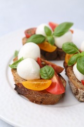 Photo of Tasty sandwiches with mozzarella cheese, tomatoes and basil on white table, closeup