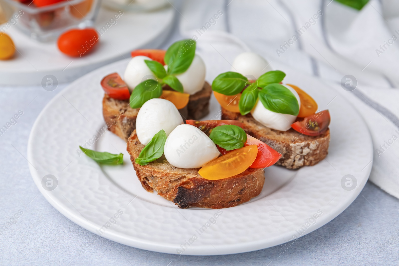 Tasty sandwiches with mozzarella cheese, tomatoes and basil on white table, closeup Photo of Tasty sandwiches with mozzarella cheese, tomatoes and basil on white table, closeup