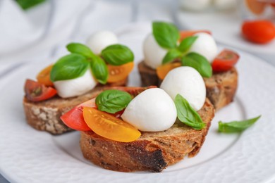 Photo of Tasty sandwiches with mozzarella cheese, tomatoes and basil on white table, closeup