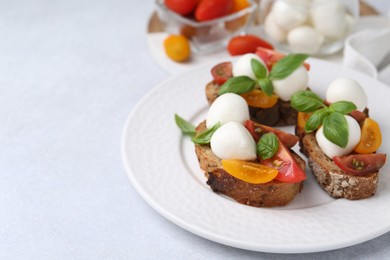 Photo of Tasty sandwiches with mozzarella cheese, tomatoes and basil on white table, closeup. Space for text