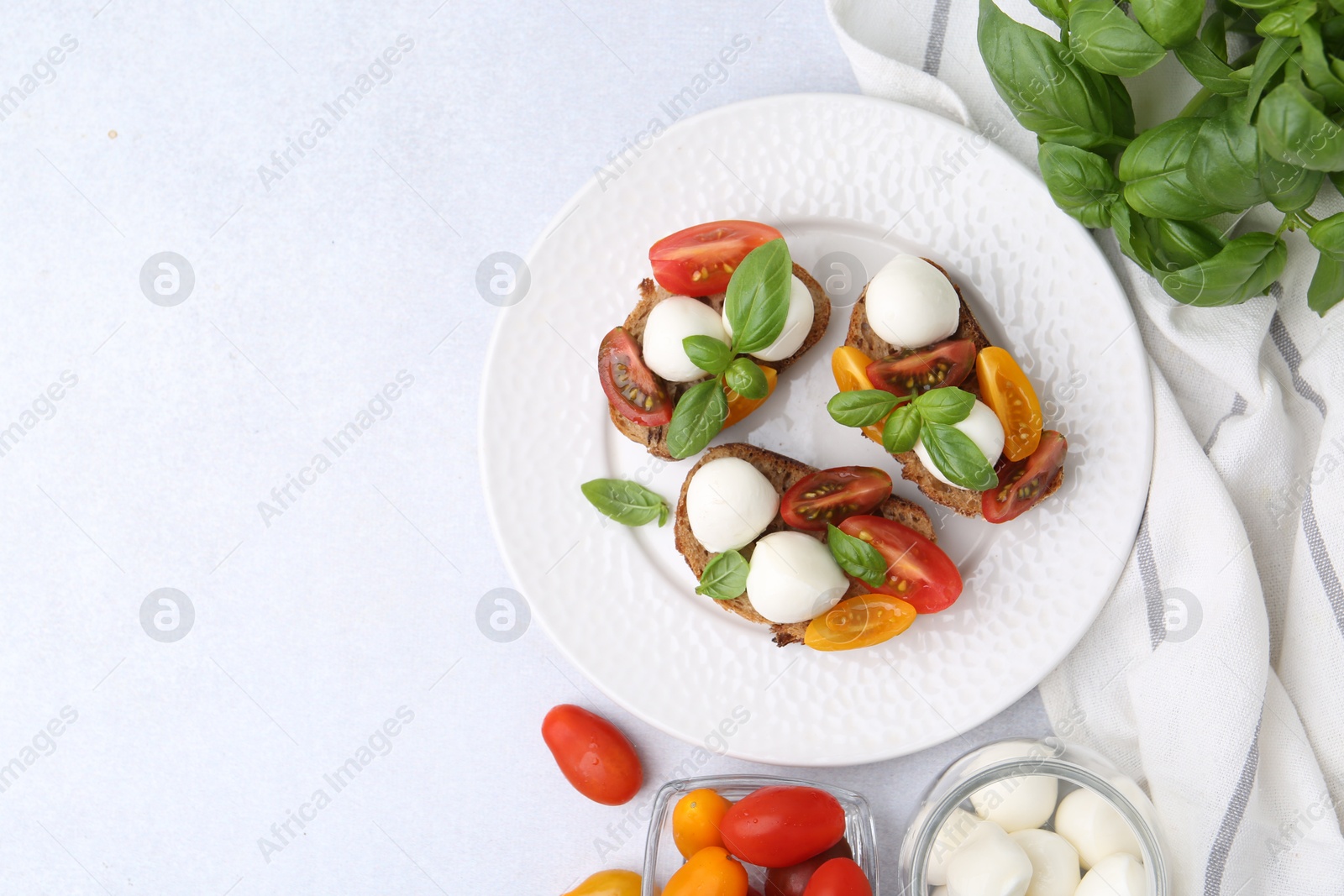 Photo of Tasty sandwiches with mozzarella cheese, tomatoes and basil on white table, flat lay. Space for text