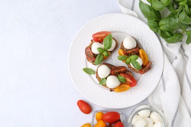 Photo of Tasty sandwiches with mozzarella cheese, tomatoes and basil on white table, flat lay. Space for text