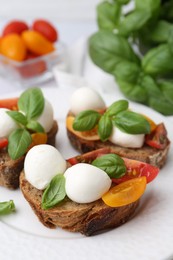 Photo of Tasty sandwiches with mozzarella cheese, tomatoes and basil on white table, closeup
