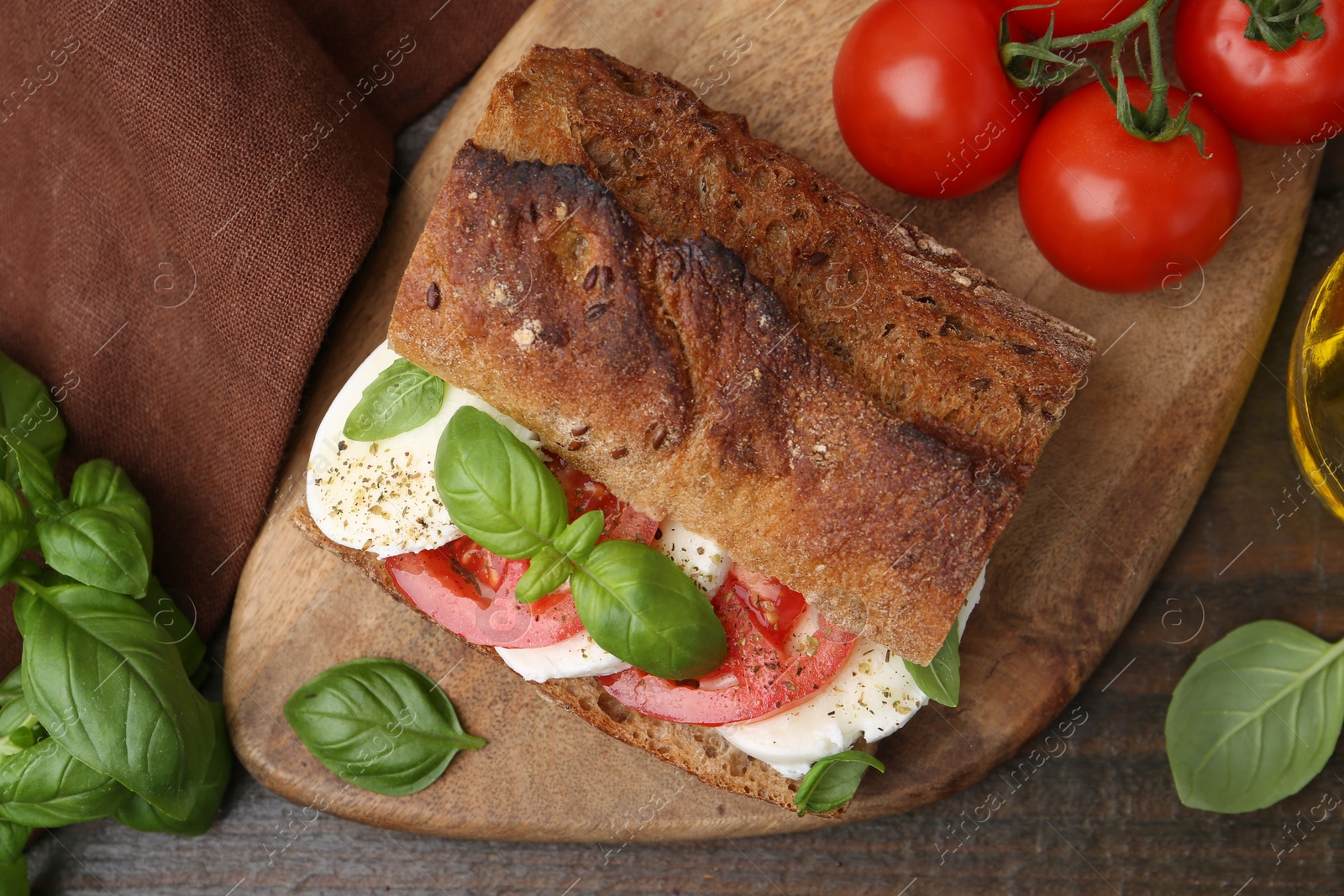 Tasty sandwich with mozzarella cheese, tomatoes and basil on wooden table, flat lay Photo of Tasty sandwich with mozzarella cheese, tomatoes and basil on wooden table, flat lay