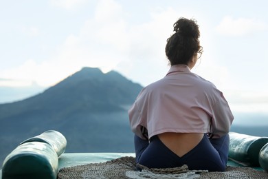 Photo of Beautiful woman enjoying picturesque view of mountains, back view. Space for text